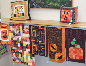 Fall decor includes quilts, table runners and pillows. 