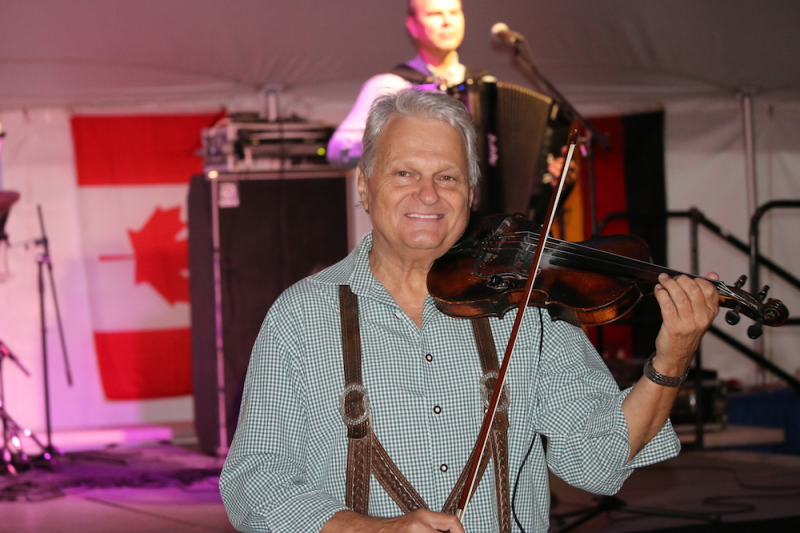 Milan Dvorecky of Europa tunes his violin for another Great Northwest Octoberfest.